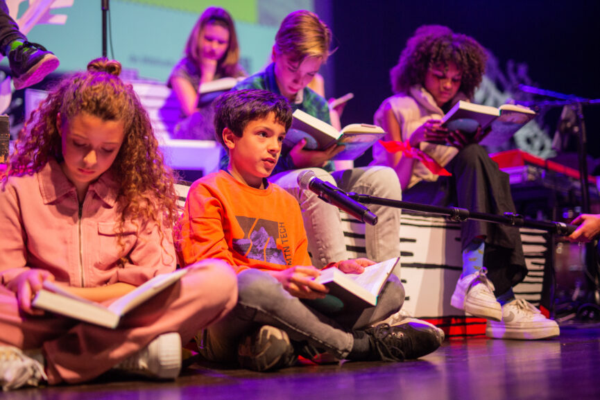 Kinderen lezen voor op podium.